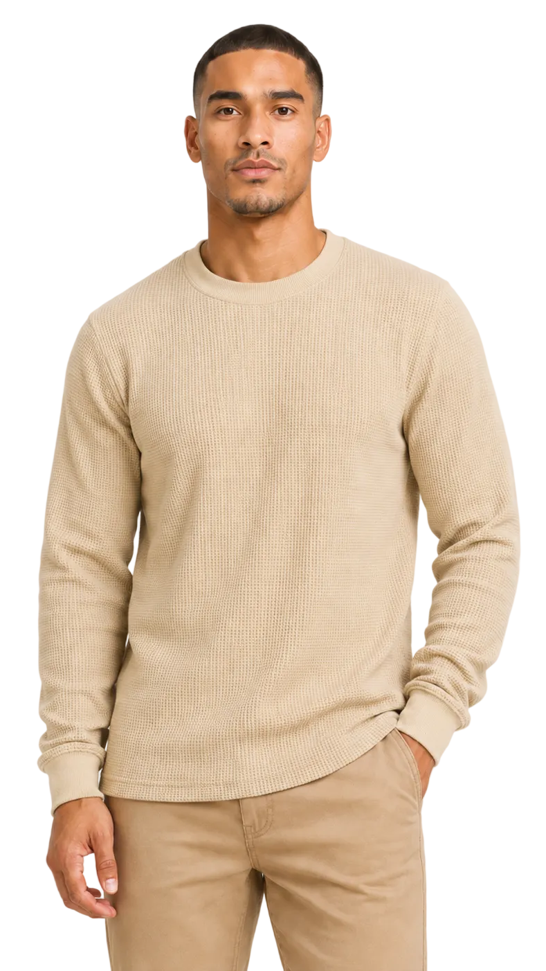 Man wearing a beige sweater and pants on a light gray background