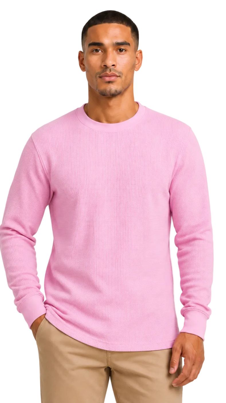 Man wearing a pink sweater and beige pants on a white background