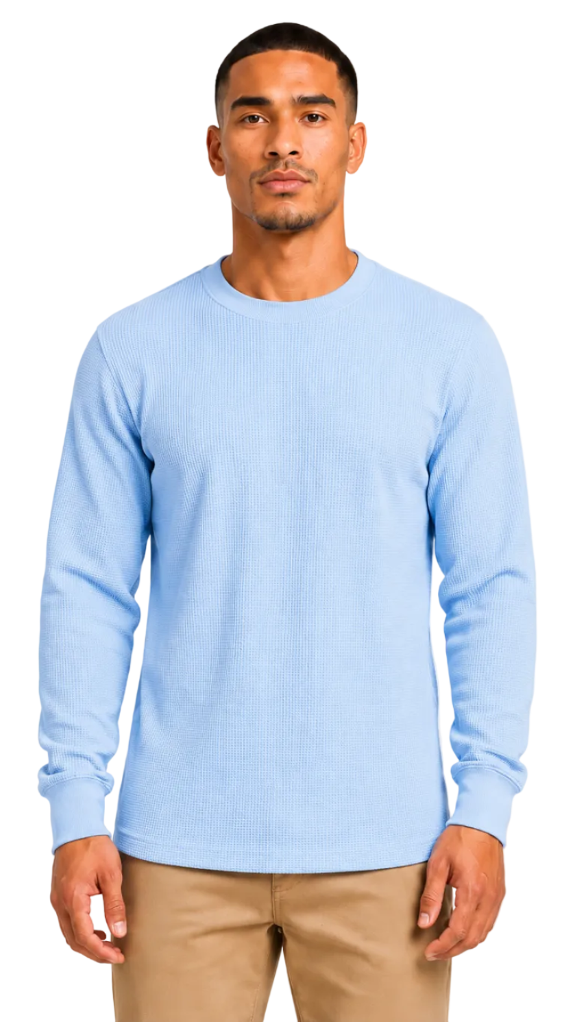 Man wearing a light blue sweater and beige pants on a white background